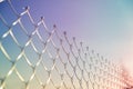 Closeup of the top edge of a rabitz fence curved wire ends. The texture of the metal mesh on the street