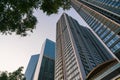 Closeup of top modern high-rise building in Kim Ma street, Hanoi, Vietnam. Mirroring of concrete skyscrapers on blue sky in shiny Royalty Free Stock Photo