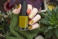 CloseUp top view of beautiful faded colors trendy manicure of green and beige glossy nails. Winter or autumn style of nail design