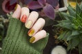 Closeup top view of beautiful faded colors trendy manicure of green and beige glossy nails. Winter or autumn style of nail design