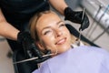 Closeup top view of cheerful blonde female patient getting dental treatment in modern clinic, dentist doctor examining Royalty Free Stock Photo