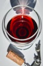 Closeup top view of a glass of red wine and corkscrew with shadows and reflections Royalty Free Stock Photo