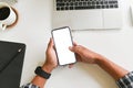 Closeup top view man hands using smartphone mockup at the white office desk. Blank screen mobile phone for montage Royalty Free Stock Photo