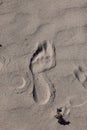 Closeup top view of one footprint in the smooth sand surface Royalty Free Stock Photo