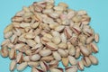 Closeup top view of pistachios in shells gathered on a blue background in a studio