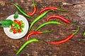 Closeup and top view red and green chili with chili sliced in a white ceramic mini bowl on wooden background Royalty Free Stock Photo