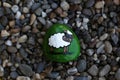 Closeup top view shot of a cute sheep-painted mountain stone