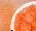 Closeup top view Slided Raw Salmon in white dish on wood blackground