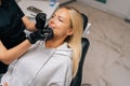 Closeup top view of smiling young woman having treatment in dentistry clinic. Cropped shot of unrecognizable female