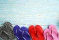 Closeup top view studio shot four pairs travel colorful summertime fashionable rubber flip flops slipper shoes placed on light