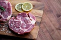 Closeup top view studio shot of two red fresh raw cut beef steak fermented with spices pepper and salt placed on wooden cutting Royalty Free Stock Photo