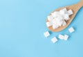 Closeup top view sugar cubes on wooden spoon white blue background Royalty Free Stock Photo