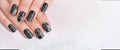 Closeup top view of two beautiful female hands with elegant classic professional fresh french black manicure