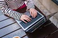Closeup top view of unrecognizable female freelancer hands typing on laptop keyboard sitting at table with coffee in Royalty Free Stock Photo