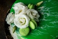 closeup topping of glazed green cake with flowers and macaroons