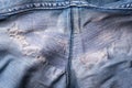 Closeup of torn old blue jeans background. texture of ripped damaged destroyed denim jeans