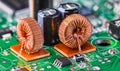 Closeup of toroidal inductors and electrolytic capacitors on electronic PCB detail with bokeh