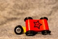 Closeup of a toy figurine of a wooden red car