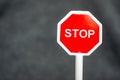 Closeup of a toy stop sign figurine on blurred gray background