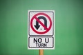 Closeup of a toy & x22;NO U TURN& x22; sign against a green background