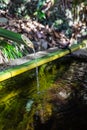 A closeup of a traditional Asian bamboo fountain with water splashing in the pool Royalty Free Stock Photo