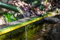 A closeup of a traditional Asian bamboo fountain with water splashing in the pool Royalty Free Stock Photo