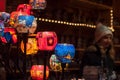 Closeup of traditional candles at christmas market with blurred woman on background