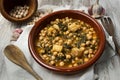 Closeup of a traditional casserole of chickpeas with spinach and cod