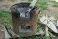 Closeup of traditional clay stove with ash and pile of firewood.