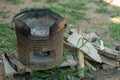 Closeup of traditional clay stove with ash and pile of firewood.