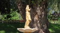 Closeup of a traditional greek style statue of a girl with a vase in Edwards garden