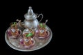 Closeup of a traditional Moorish mint tea service, with decorated glassware and silver teapot Royalty Free Stock Photo