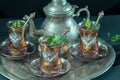 Closeup of a traditional Moorish mint tea service, with decorated glassware and silver teapot Royalty Free Stock Photo