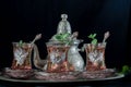 Closeup of a traditional Moorish mint tea service, with decorated glassware and silver teapot Royalty Free Stock Photo