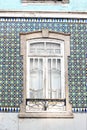 Closeup of traditional Portuguese house facade decorated by beautiful ceramic azulejo tiles Old white wooden window on Royalty Free Stock Photo
