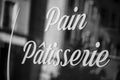 traditional sign on french bakery window in french : pain, patisserie, in english : bread, pastry