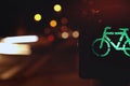 closeup on traffic light for a cycling lane showing green bicycle symbol in colorful night scene