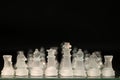 Closeup of transparent chess pieces on a board against a dark background Royalty Free Stock Photo