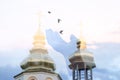 A hand releasing the birds between the church domes