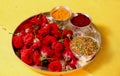 Closeup of a tray of red roses with powder spices and colorful rice on it Royalty Free Stock Photo