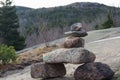 Closeup of tree stones lining up on one another with forested hill in the background