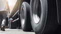 Closeup a truck wheels and a truck driver holding clipboard walking with inspecting safety vehicle maintenance checklist. Royalty Free Stock Photo