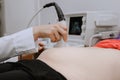 A closeup of tummy of pregnant woman having ultrasound scan in hospital Royalty Free Stock Photo