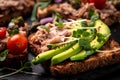 Closeup of a tuna melt topped with avocado and microgreen, on wholemeal bread. Italian cuisine, Delicious breakfast or snack Royalty Free Stock Photo