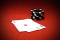 Closeup of two Ace playing cards with poker chips on a red surface Royalty Free Stock Photo