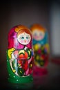 Closeup of two colorful Russian wooden matryoshka dolls standing on shelf.