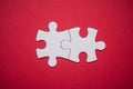 two connected jigsaw puzzle pieces on red background. The concept of finding the right solutions in teamwork Royalty Free Stock Photo