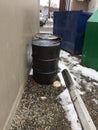 Closeup of two dirty greasy barrels outside building with garbage and recycling bin. Royalty Free Stock Photo