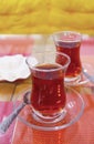 Two Glasses of Hot Turkish Tea with a Plate of Sugar Cubes in the Backdrop Royalty Free Stock Photo
