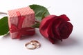 Closeup of Two gold wedding rings with pink gift box and wedding bouquet Royalty Free Stock Photo